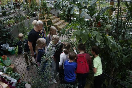 Tartu loodusmaja õpilased koos õpetajaga seismas talveaias ümber taimede